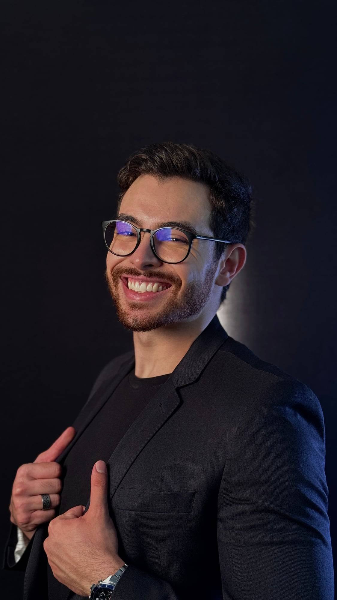 Barbosa de terno escuro, sorrindo, sobre fundo preto